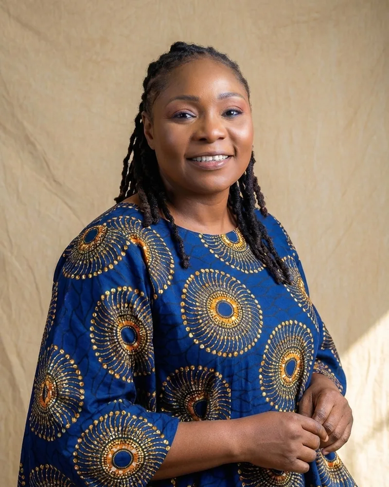 Dr Oluwakemi Damola Adejumo-Ayibiowu, wearing an indigo and gold adire-print dress